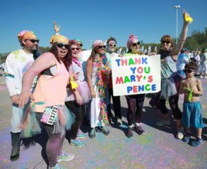 Staff from Maya Organization gathered after Color Run 5K holding sign thanking Mary's Pence