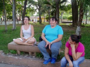 Gaby sitting on a bench talking with two women in Suchitoto, El Salvador.
