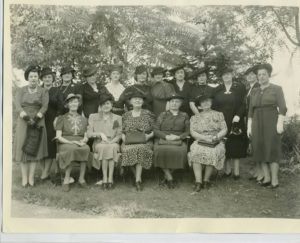 Old photo of a group of women from 1940s at a tea party.