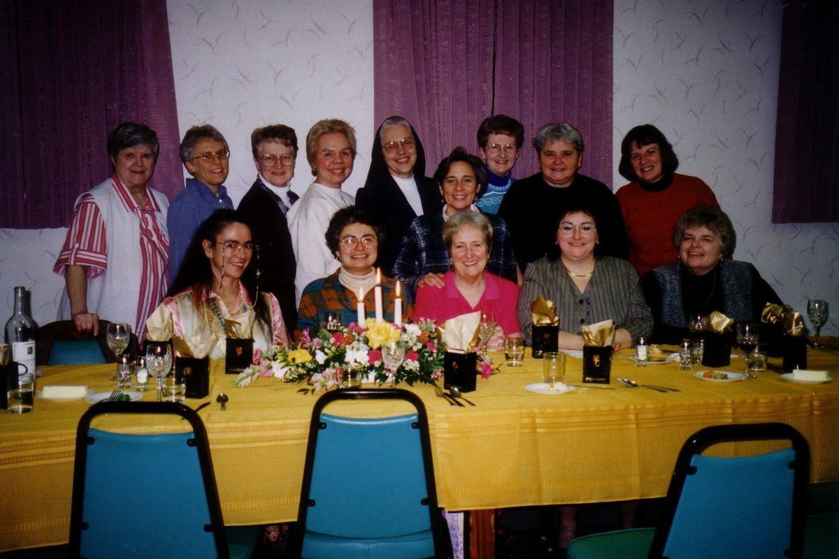Photograph of Maureen Gallagher seated at a table surrounded by other women.