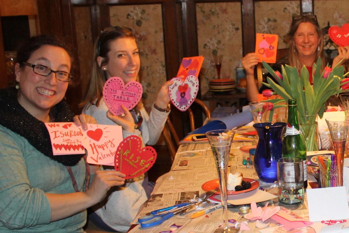 Photograph of bridgette with two other women holding up homemade valentines.