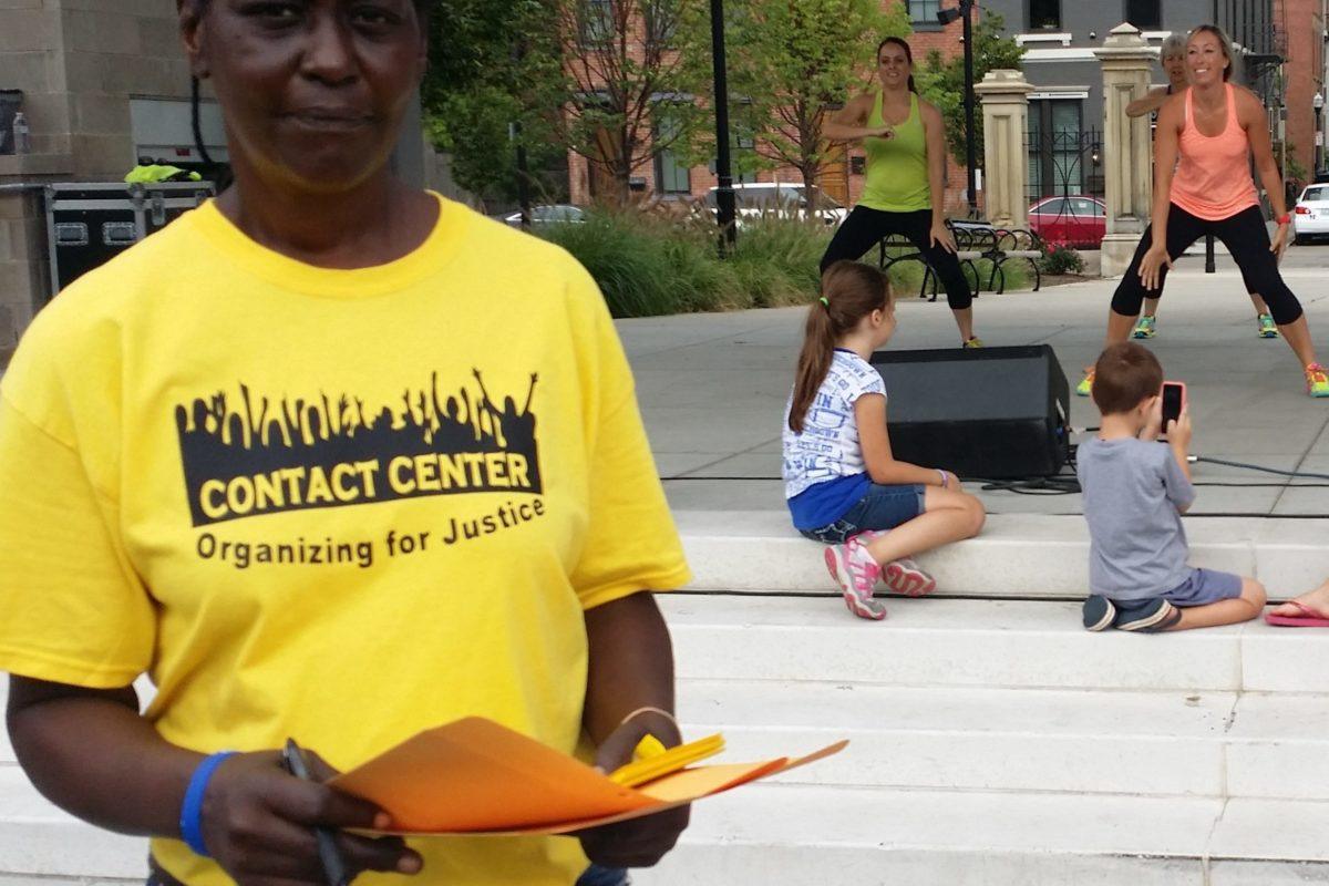 Photograph of a woman in a yellow shirt that says Contact Center Organizing for justice.