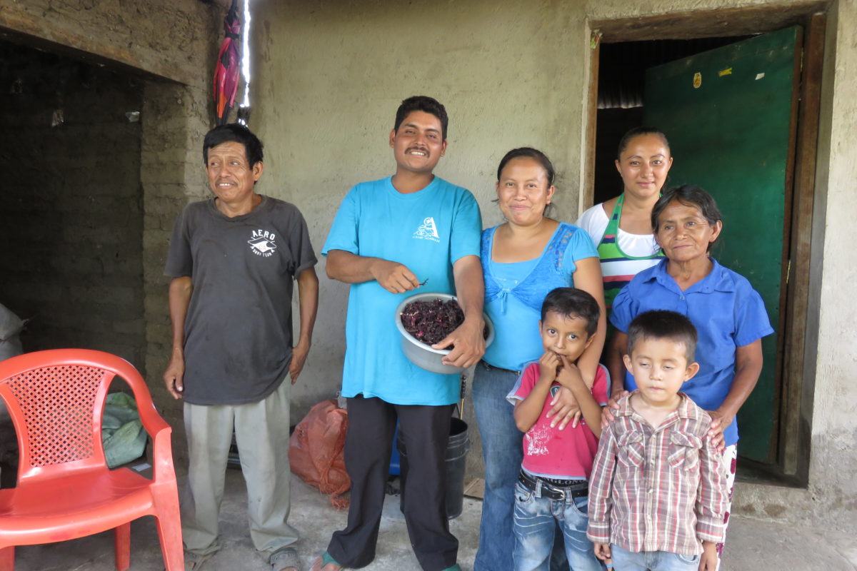 Photograph of a family outside their home near Suchitoto. Grandfather, father, mother, and four children.