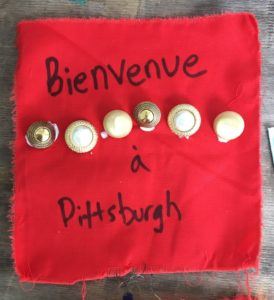 A red cloth that syas Bienvenue a Pittsburgh