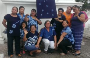 Photograph of a group of women all wearing shirts and/or pants made from indigo-dyed fabric.