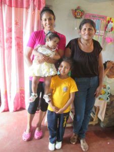 Photograph of two adult women, one young girl, and one toddler posing for the camera.